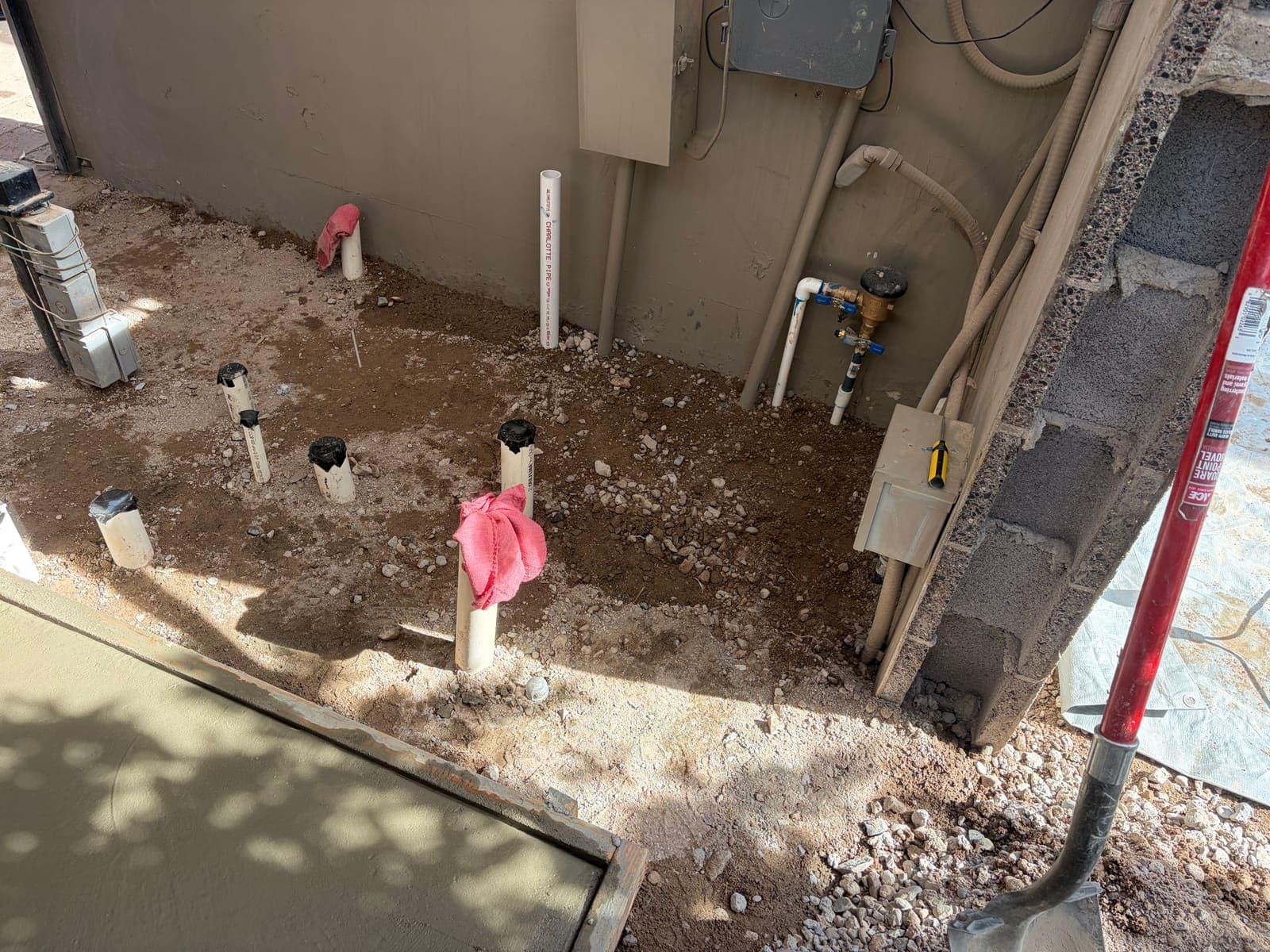 New plumbing stub-outs and fresh concrete during a full equipment-pad re-plumb
