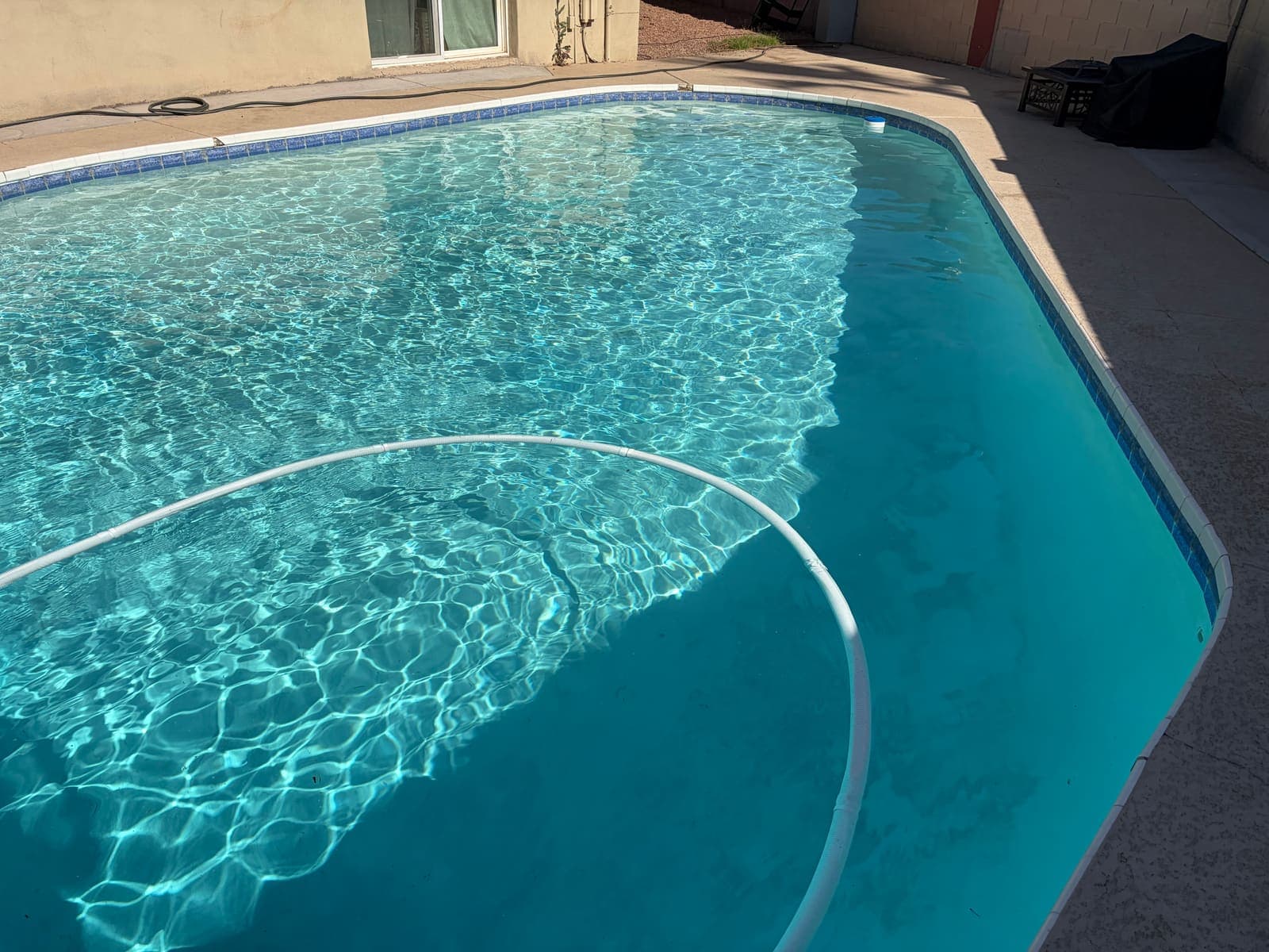 Crystal-clear water with sunlight ripples in a South Tempe pool after its weekly visit